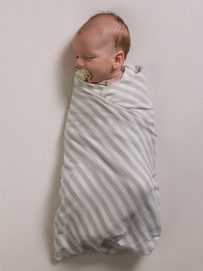 Baby in Woolbabe swaddle with dummy