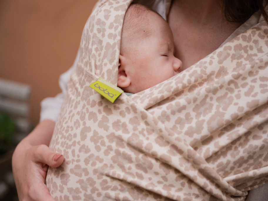 A newborn baby in a sand leopard boba wrap 