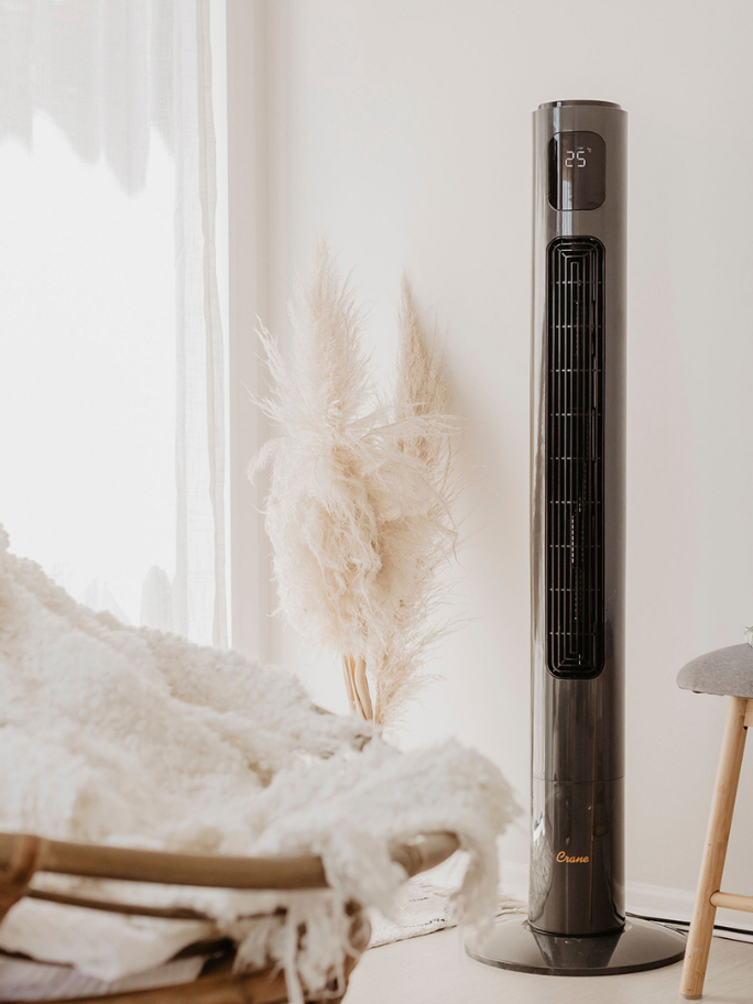 Crane Tower Fan in home setting with soft furnishing