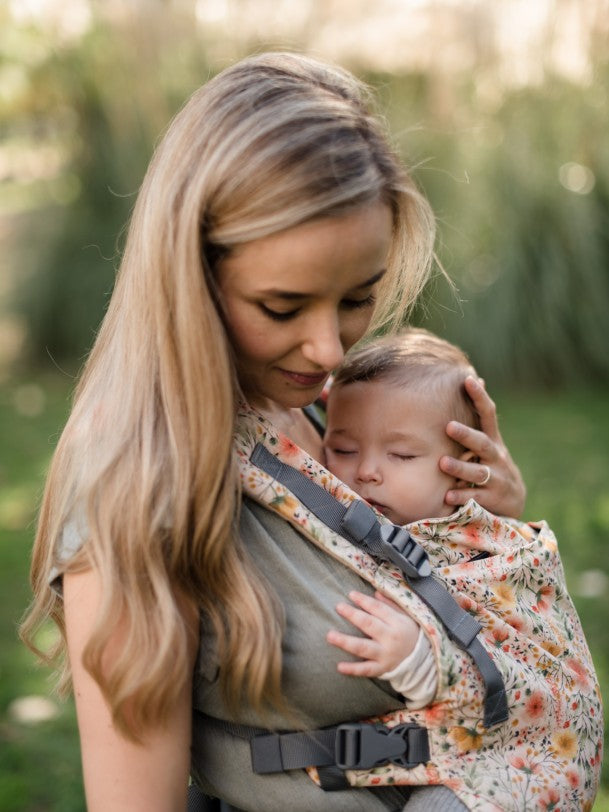 Mother wearing baby in floral carrier