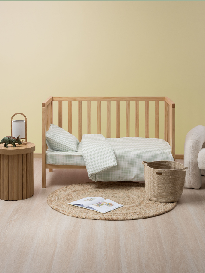 Studio nursing setting including a cot in toddler bed setting with bedside and dinosaur toy