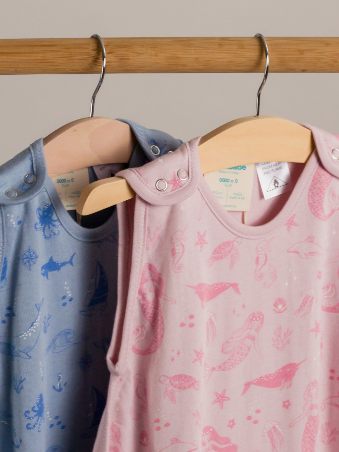 Close up of two woolbabe sleeping bags hanging on a curtain rack
