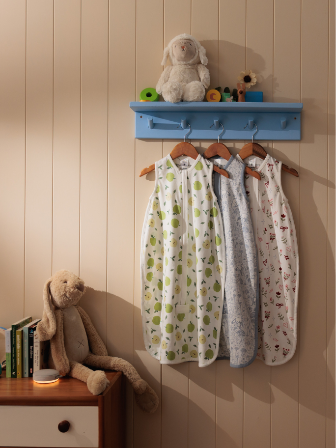 Three cotton sleeping bags in different prints hanging in a bedroom setting