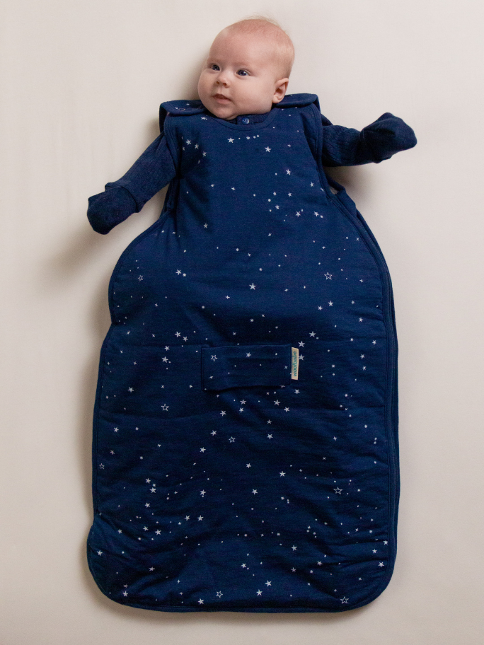 Baby in navy stars duvet woolbabe sleeping bag and matching PJ suit