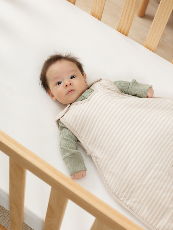 Baby in woolbabe sleeping bag in cot