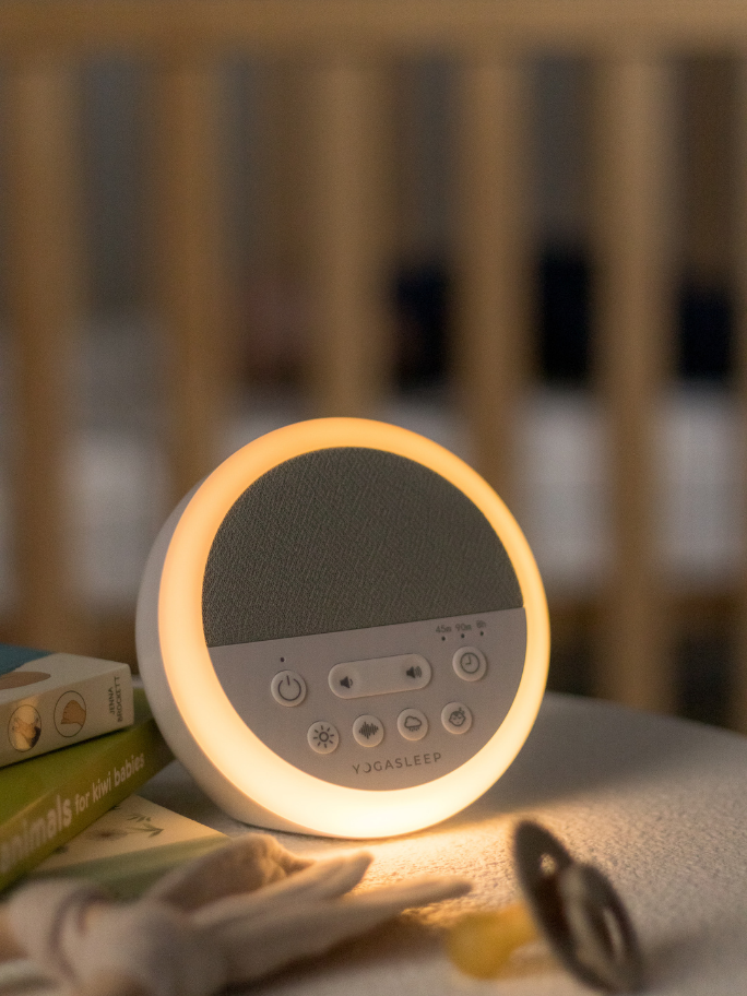 Nod white noise machine with soft light on a bedsie table
