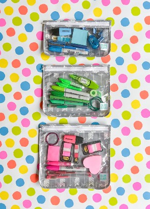 3 clear travel bags filled with neon highlighters and stationery against a polkadot background