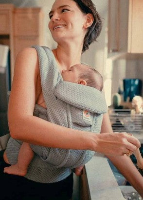 Mum wearing newborn baby in omni deluxe baby carrier