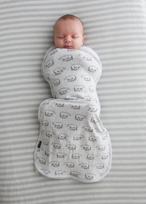 Sleeping newborn in bear print The Sleep Store fitted zip swaddle with knees up