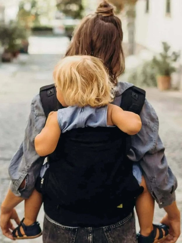 Mum carrying baby on back in beco gemini baby carrier
