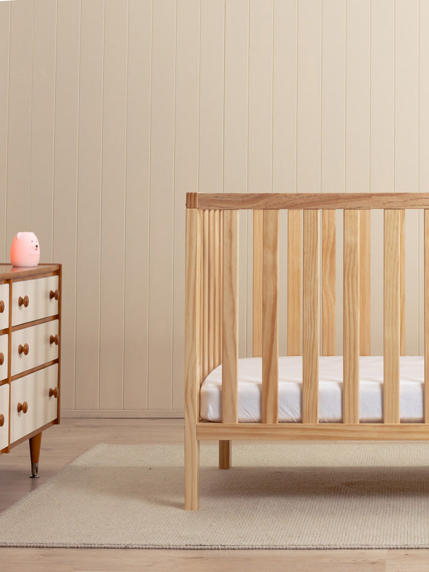 Wooden cot in a neutral nursery setting