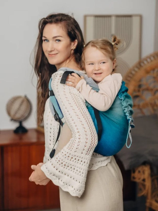 Woman carrying toddler on back in Onbuhimo style carrier