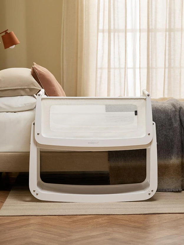 Snuzpod bedside bassinet next to a bed