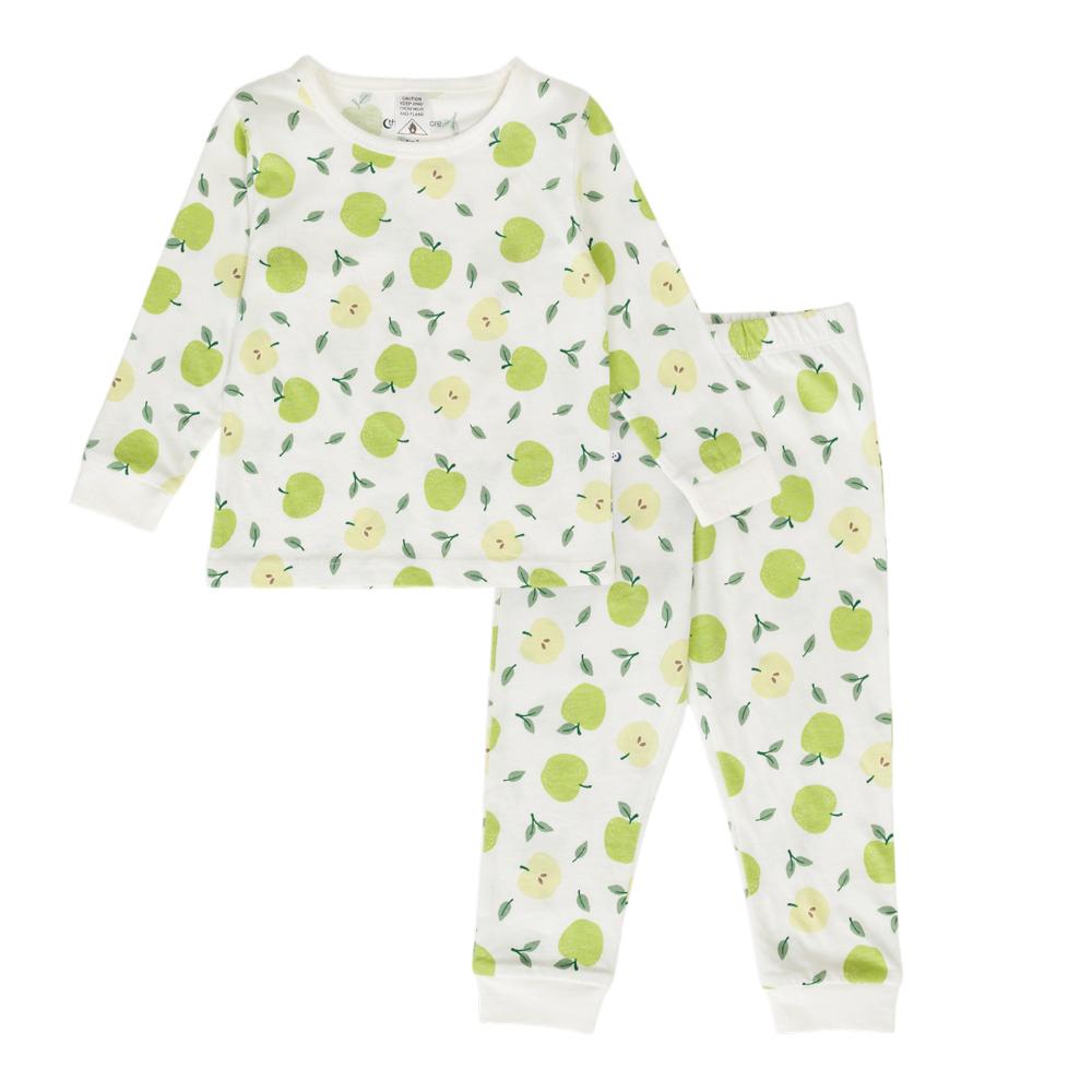 Child in cotton apple print pyjamas on a white background