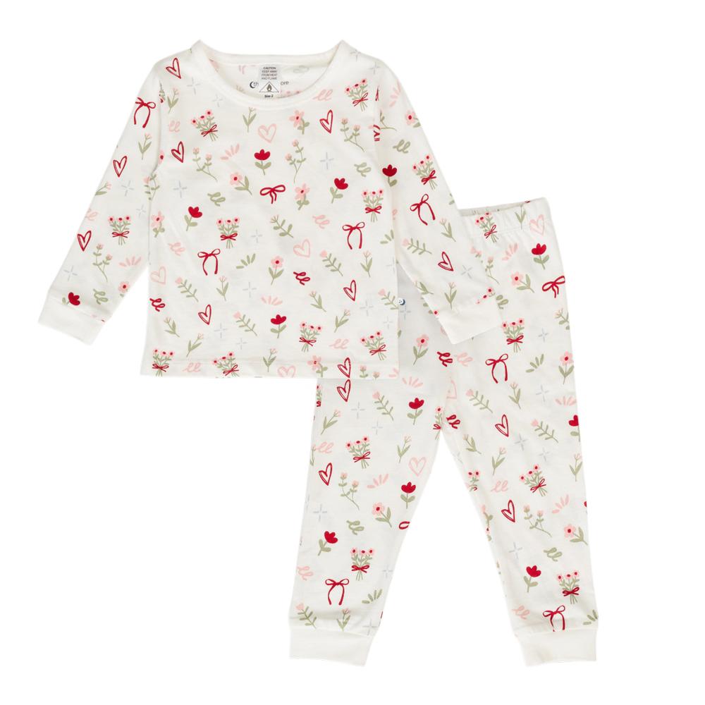 Child in cotton white floral print pyjamas on a white background