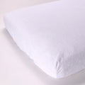 White terry mattress protector on a mattress with a light background