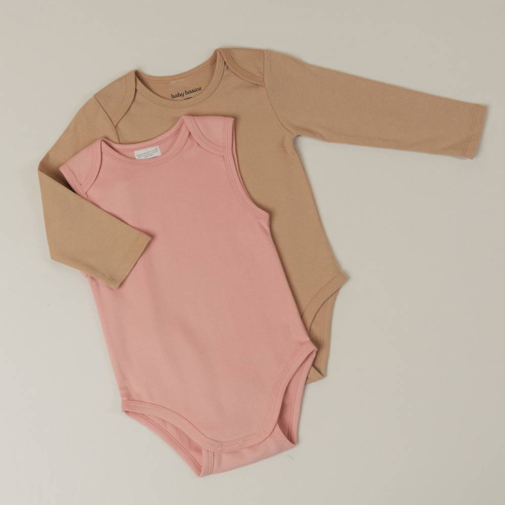 Two baby organic cotton bodysuits, one pink and one beige, on a light background
