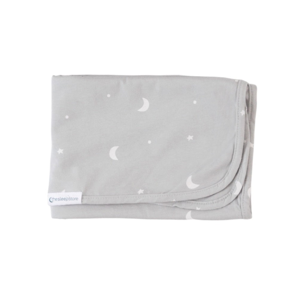 Folded gray blanket with white moon and star patterns on a white background