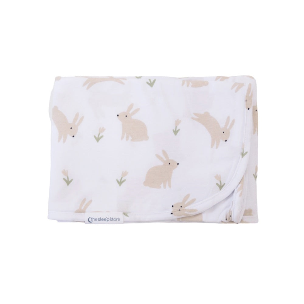 Folded baby swaddle blanket with rabbit pattern on a white background