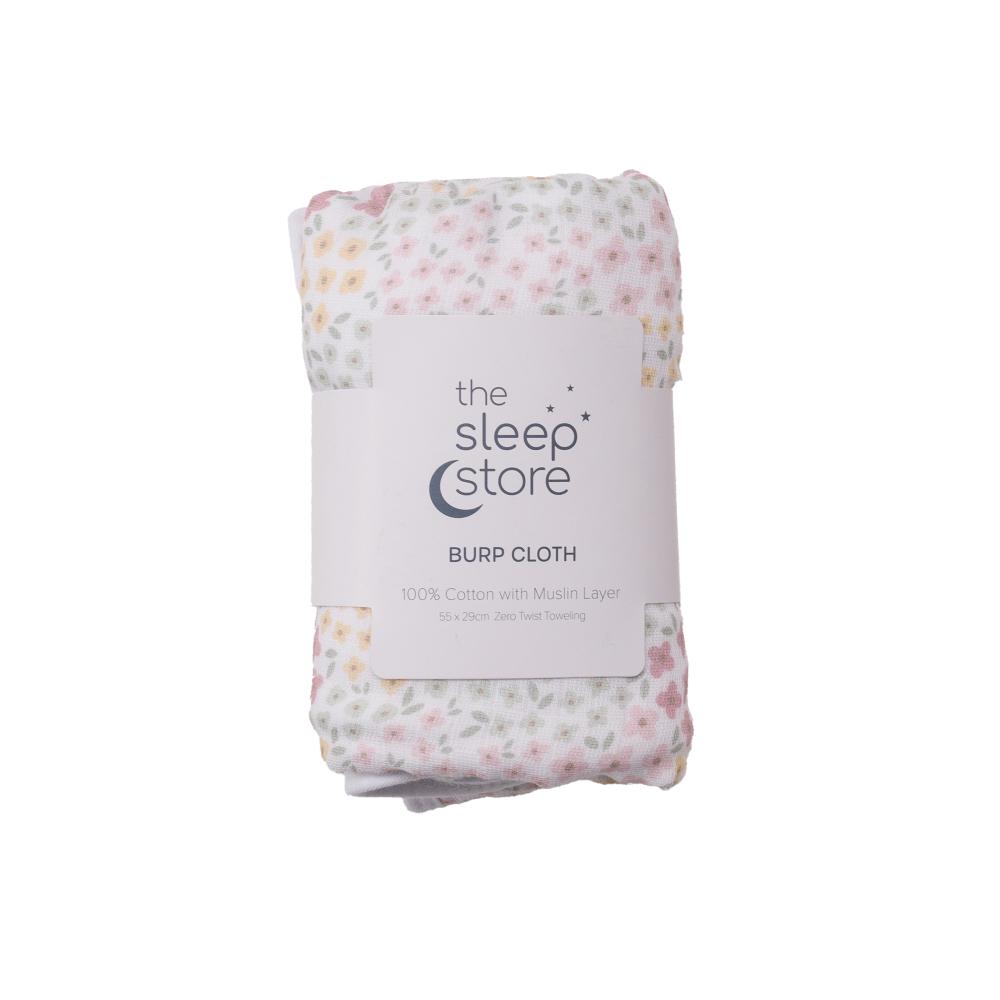 Packaged burp cloth with floral pattern and 'The Sleep Store' branding on a white background