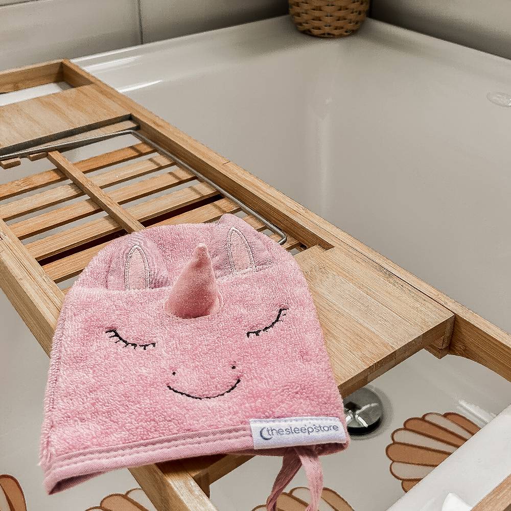 Pink unicorn wash mit a label on a wooden tray