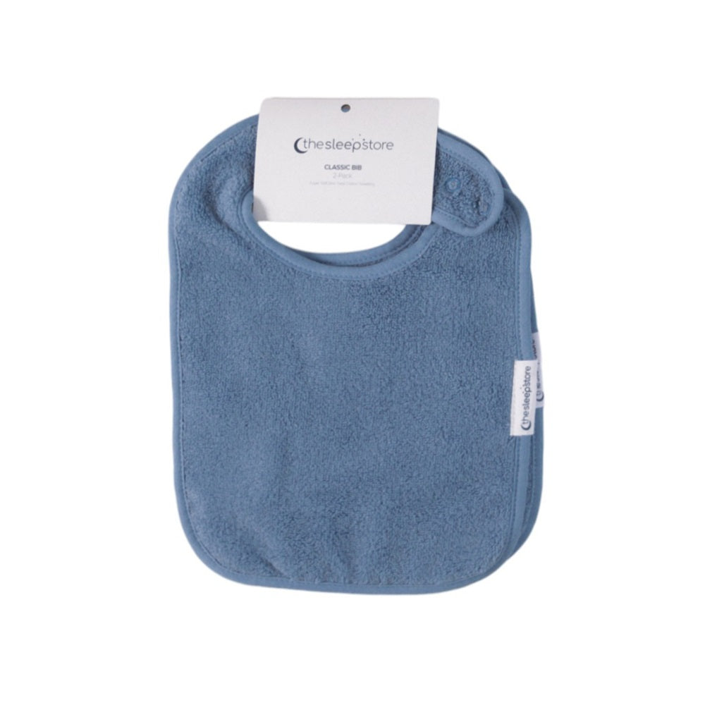 Blue terry towelling bib with The Sleep Store brand label on a white background