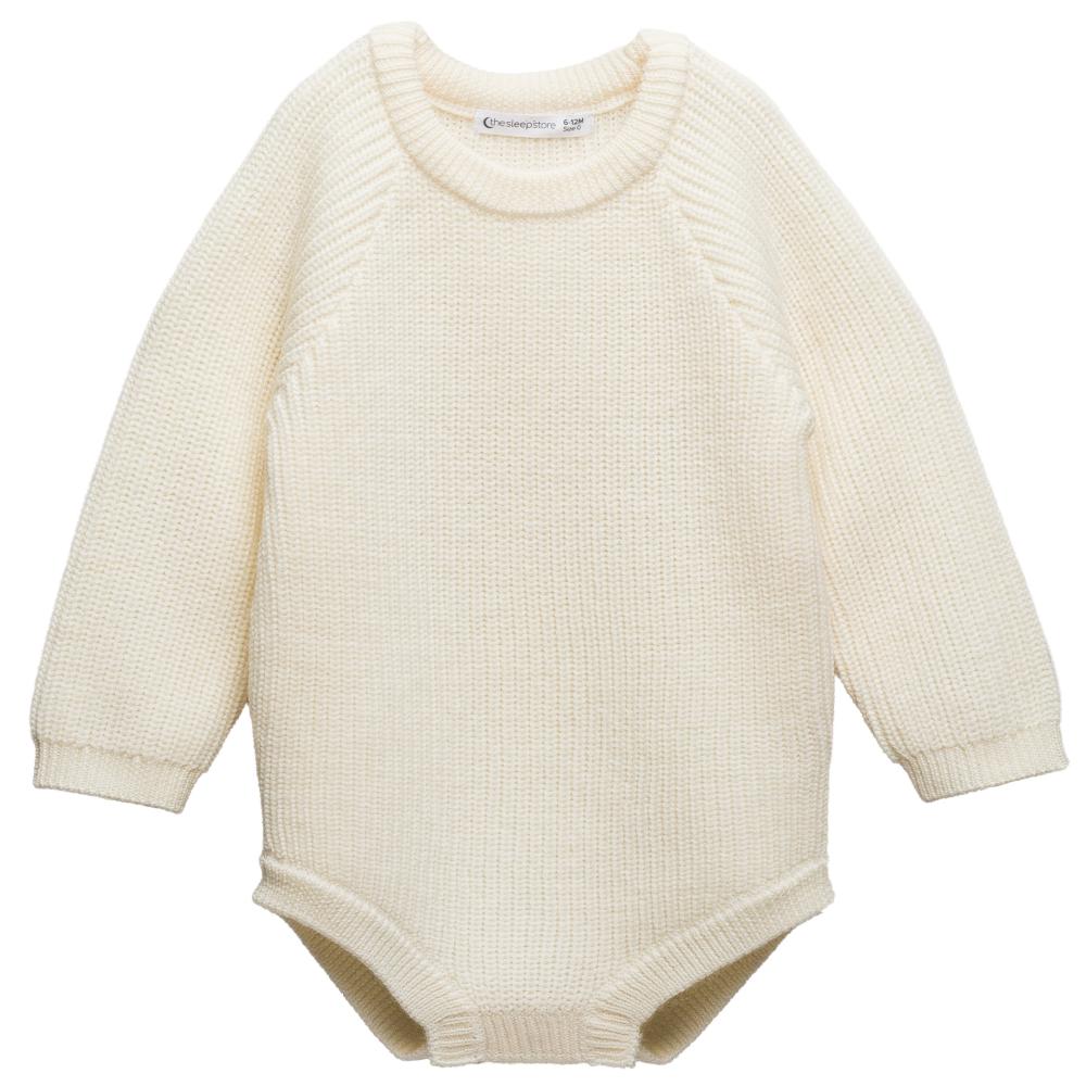 Cream-colored knitted merino wool baby bubblesuit romper on a white background