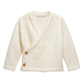 Cream-colored merino wool knitted baby kimono cardigan with buttons on a white background