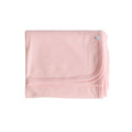 Pink deluxe rib merino wool blanket with a small 'The Sleep Store' brand logo on a white background