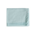 Light blue deluxe merino rib blanket with small logo on a white background