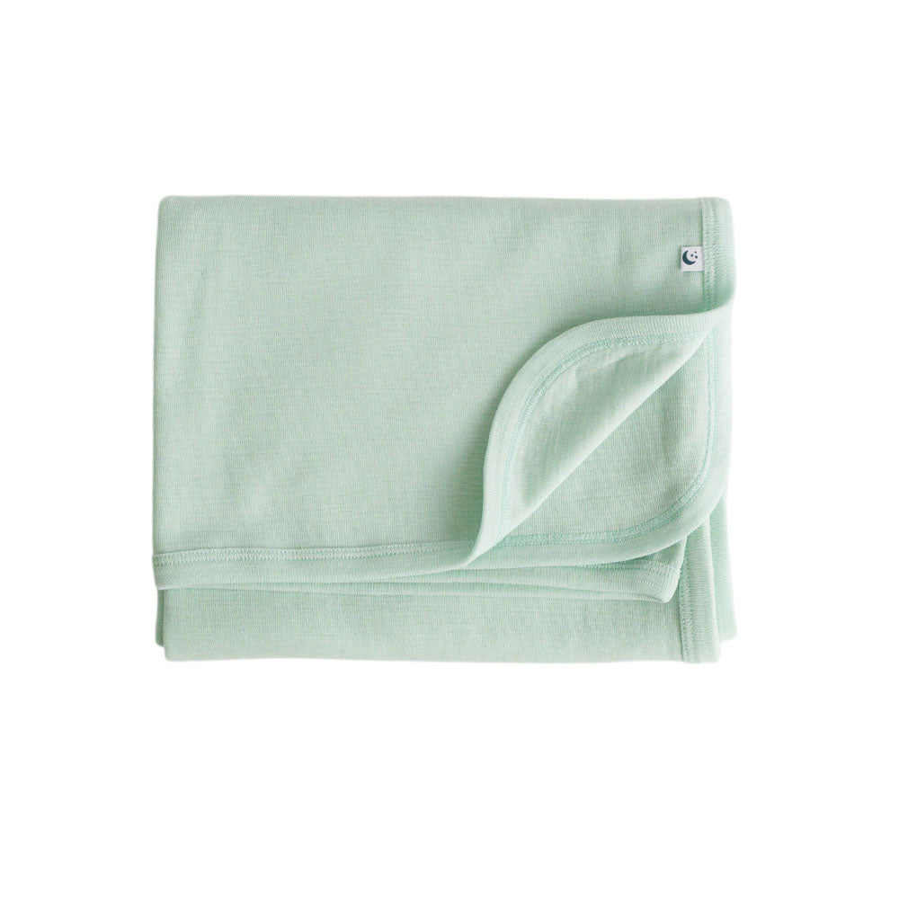 Folded light green deluxe merino with a sleep store brand logo on a white background