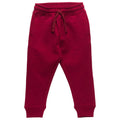 A pair of kids' jogger merino fleece sweatpants in a deep burgundy red, featuring an elastic waistband with a matching drawstring and ribbed ankle cuffs, shown against a plain white background.