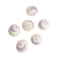 Six cream coloured woolen dryer balls il purple star and moon pattern against a white background