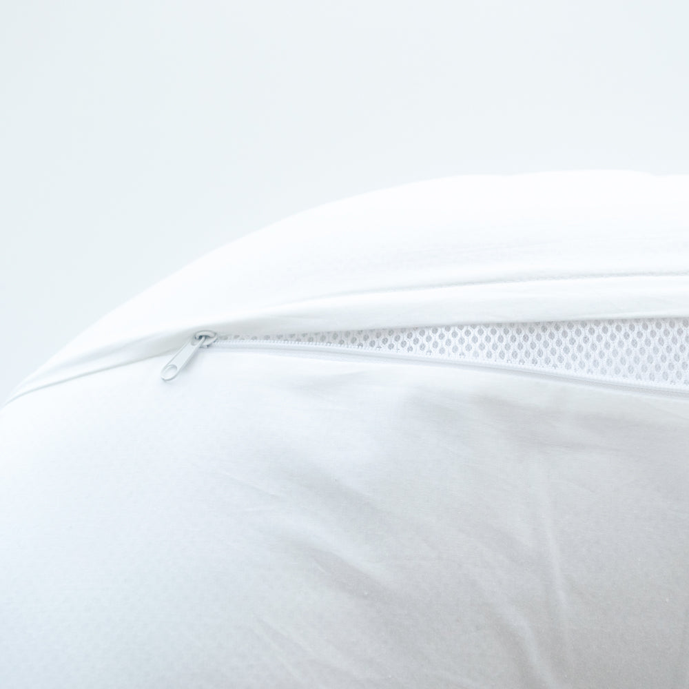 Close-up of a white pillow with a zipper on a light gray background