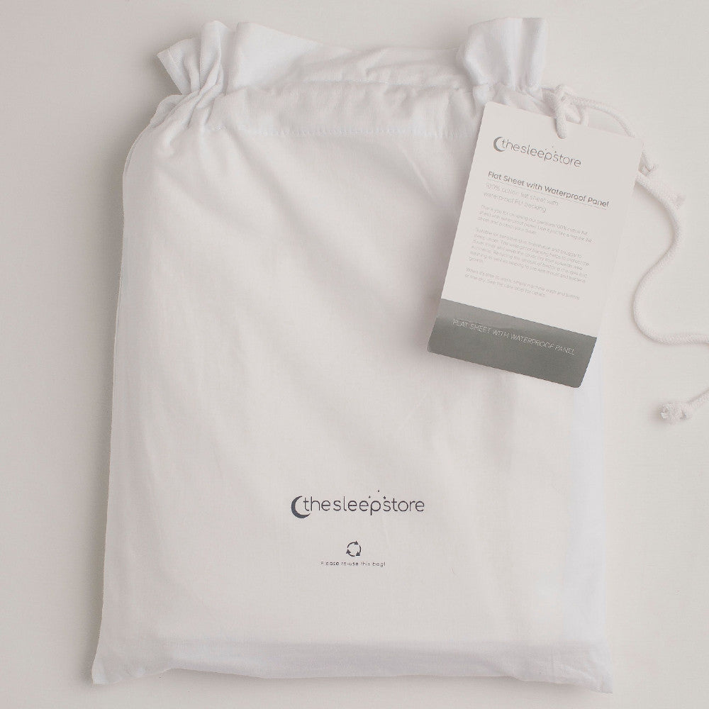 Folded white waterproof bedwetting protector sheet in a Sleep Store cloth bag