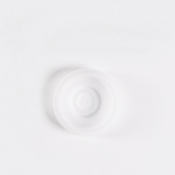 Clear silicone diaphragm disc for breast pump on a white background