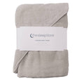 A folded light gray cotton terry hooded baby towel with a white paper label band around the middle, photographed on a plain white background. The label shows the brand name 'thesleepstore'.