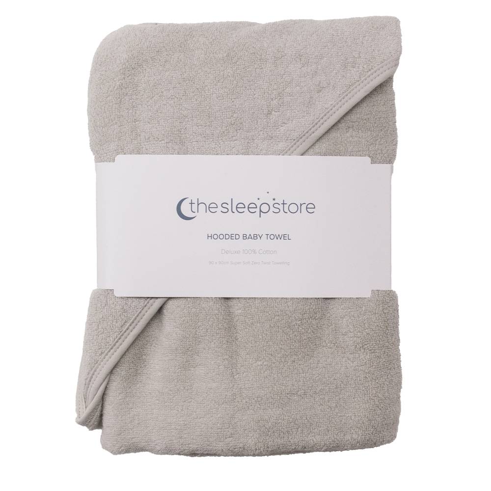 A folded light gray cotton terry hooded baby towel with a white paper label band around the middle, photographed on a plain white background. The label shows the brand name 'thesleepstore'.