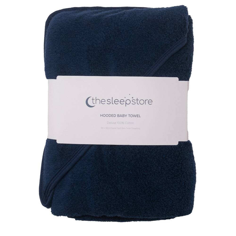 A folded navy blue cotton terry hooded baby towel wrapped in a white paper band labeled 'the sleepstore HOODED BABY TOWEL'.