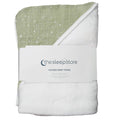 A folded hooded baby towel from thesleepstore, featuring a sage green muslin top with white star print and a plush white underside, wrapped in a white paper band.