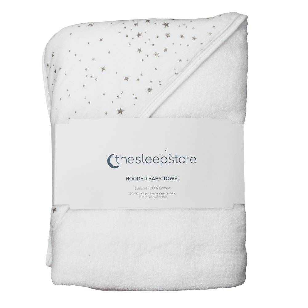A folded white hooded baby towel with small star and moon print on one side, wrapped in a white paper band labeled 'the sleep store'.