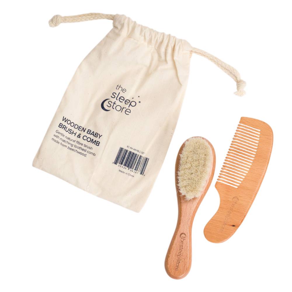 Wooden baby brush and comb set with a drawstring bag from The Sleep Store on a white background.