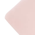 The corner of a mattress with a blush pink colour fitted sheet, on a white background. 