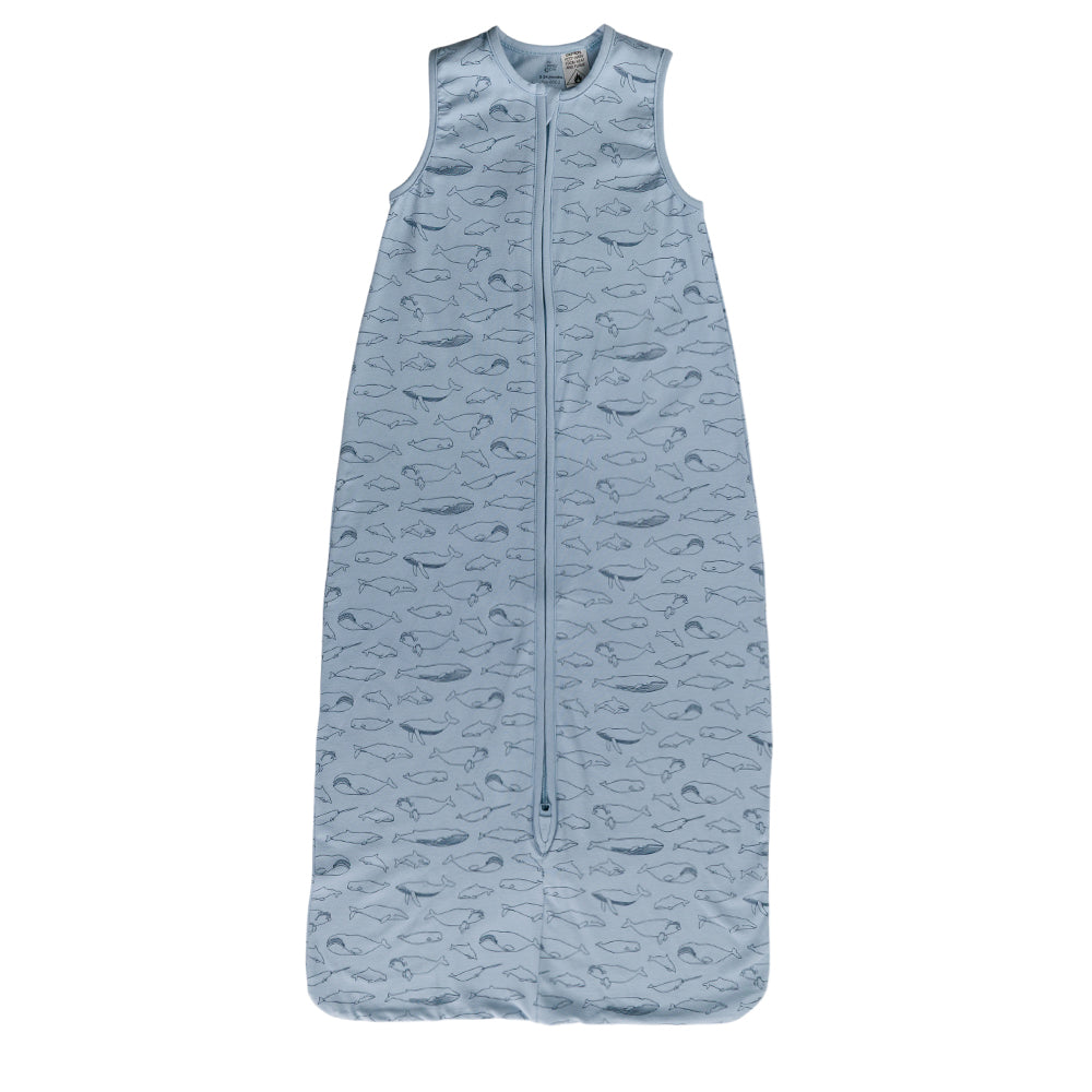 A sleeveless cotton baby sleep sack with blue whales on a blue background, shown flat against a white background.