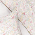 Cotton Floral patterned cot duvet and pilow with small pink and yellow flowers on a light background