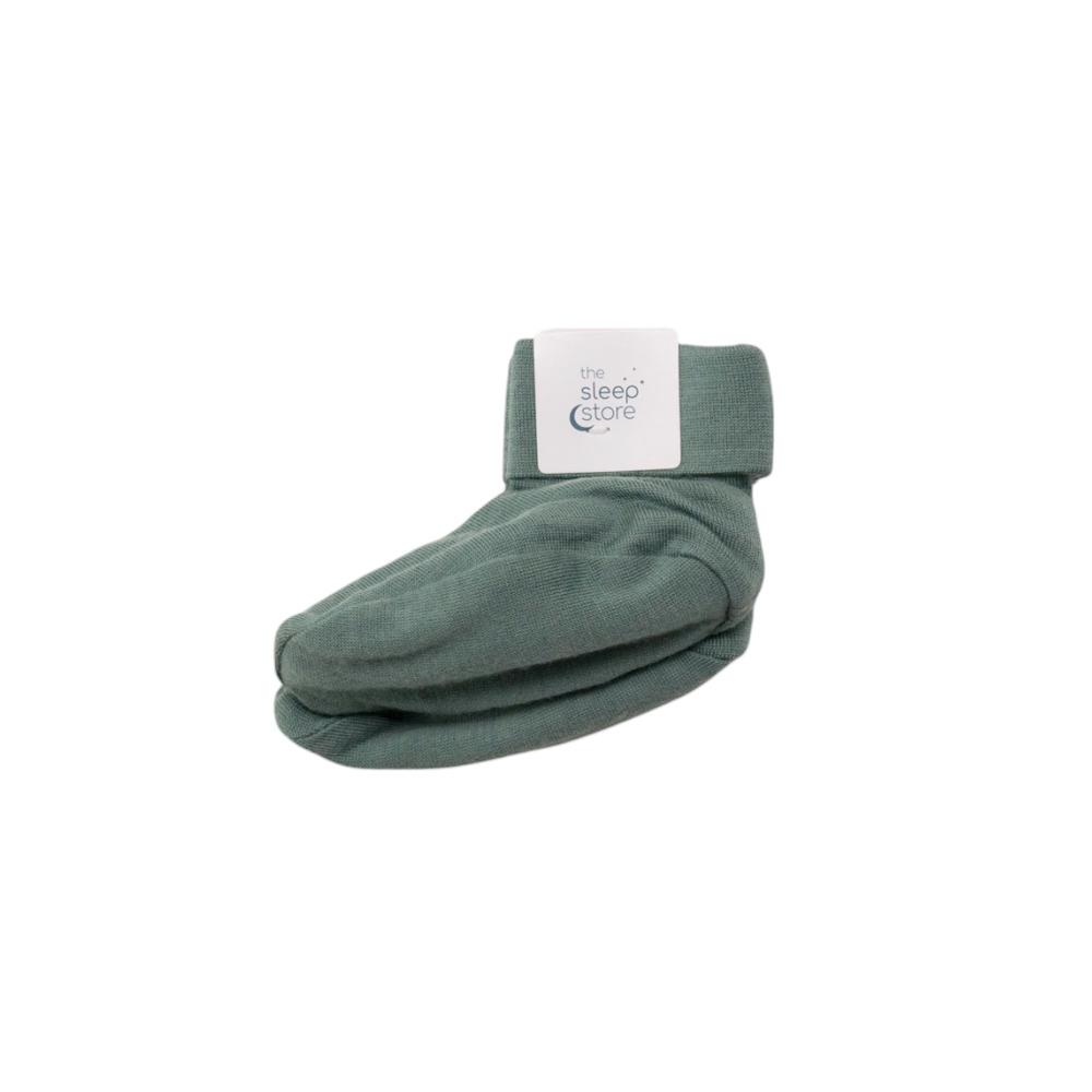 Green baby booties with a label on a white background