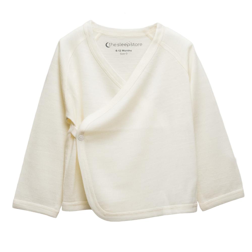 An off-white long-sleeve baby kimono cardigan wrap with a V-neck and snap closure, shown on a plain white background. The brand 'the sleep store' is printed inside the collar.
