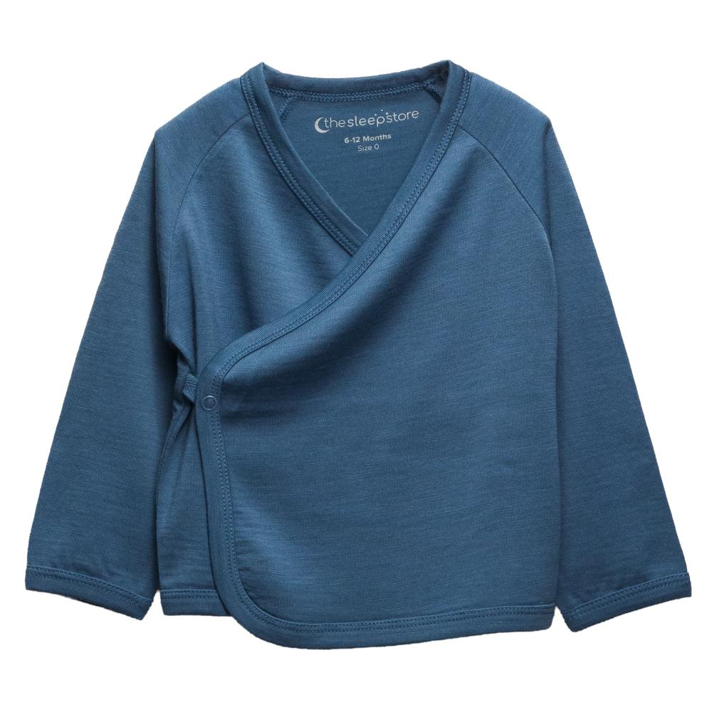 A deep blue baby jersey merino wrap jacket by The sleep store, featuring a V-neck, long raglan sleeves, and a side button closure, displayed flat against a white background.