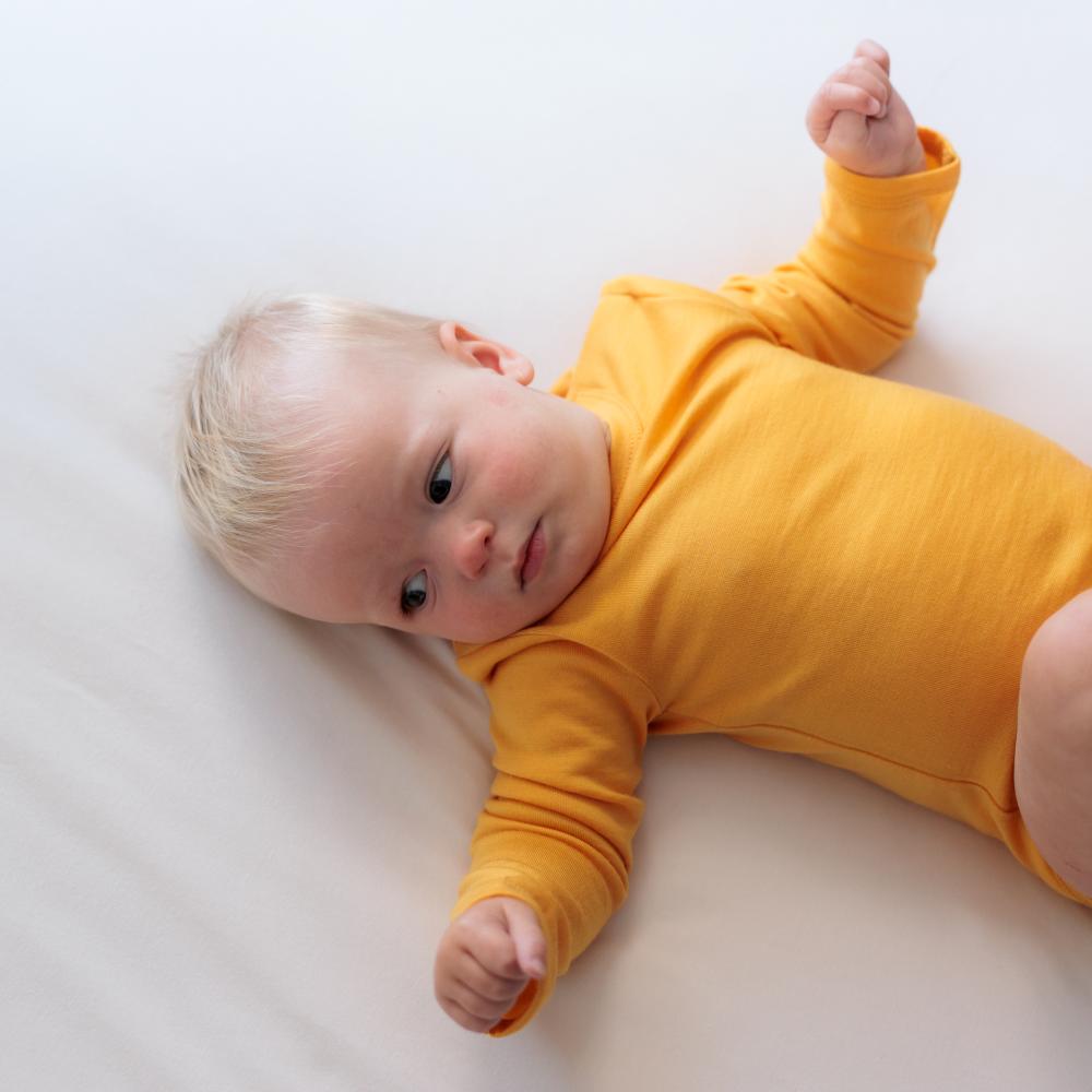 Baby wearing merino golden yellow merino bodysuit