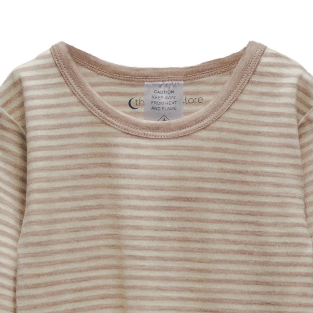 Close-up of a childrens merino shirt with a striped pattern and a visible brand label on a white background.